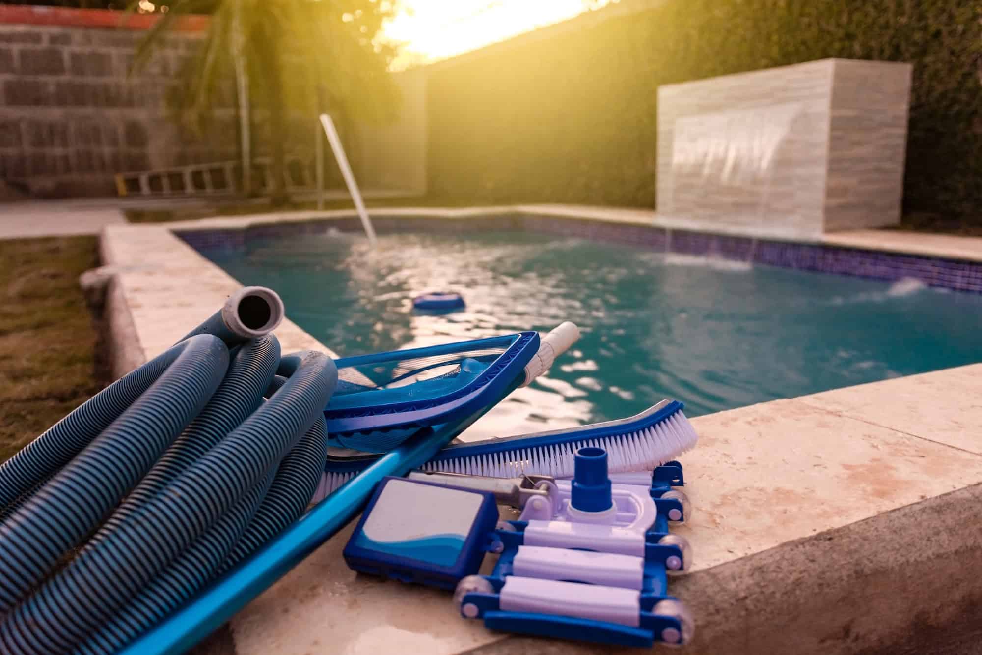 Professional pool cleaning tools and equipment at sunset